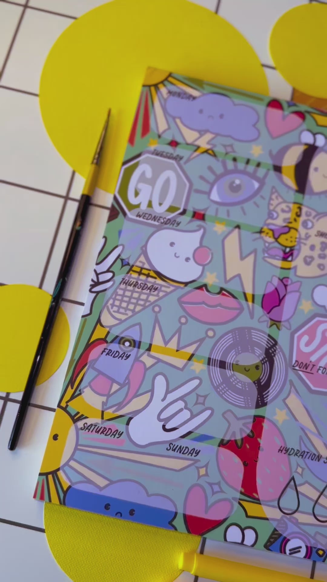 Video of a4 desk planner by the Stoofy store. Fun. Dopamine. Stationary lover. ADHD planner. Illustrated pattern including: suns, leopards, records, hearts, ice cream, crown, peace hand sign, lips, rocket, moon, strawberry, rose, cloud, four leaf clover, stop sign, go sign, eye, bumble bee, lightning, camera, chocolate.